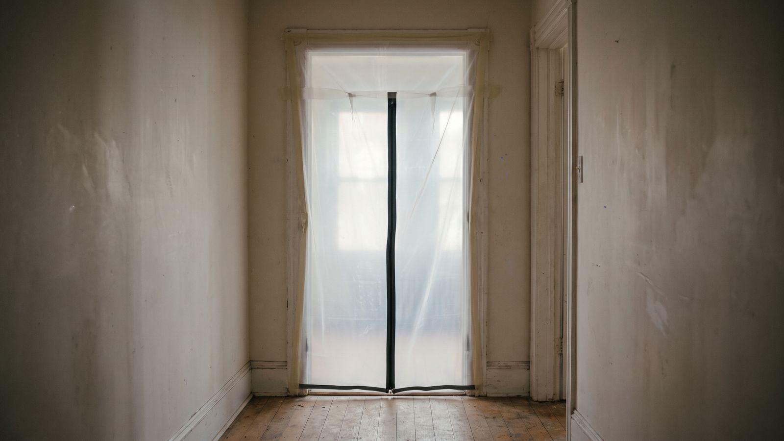 Zippered plastic sheeting sealing a doorway Zippered plastic sheeting sealing a doorway so mold on drywall stays contained during removal