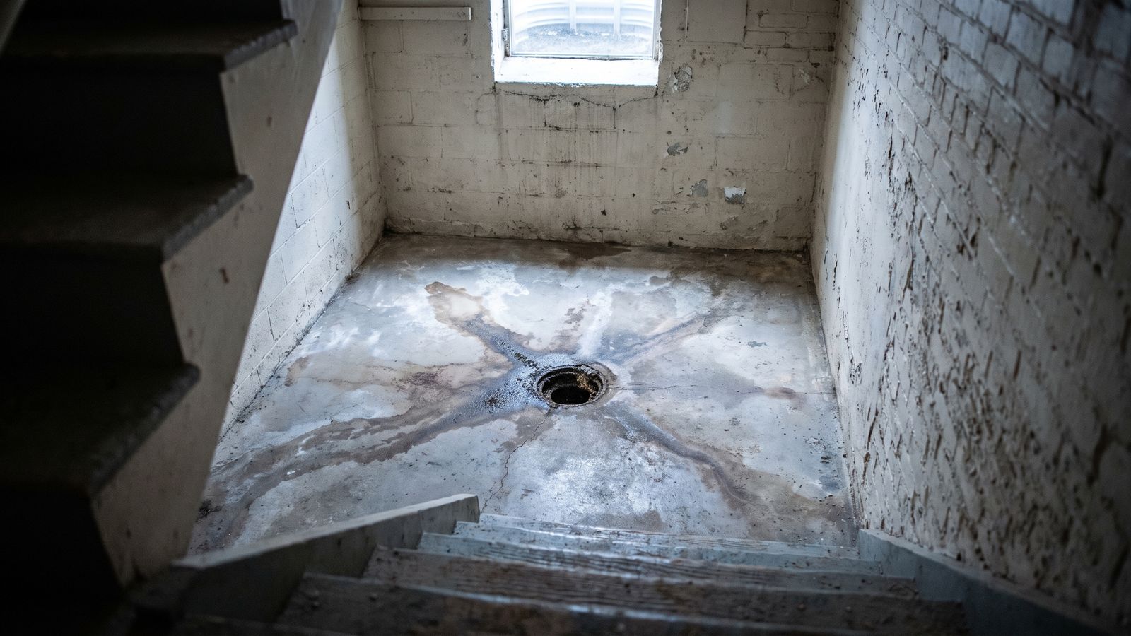 Sewer backup insurance endorsement DC: basement floor drain Open basement floor drain ringed by dark staining, the loss a sewer backup insurance endorsement in DC pays to clean up