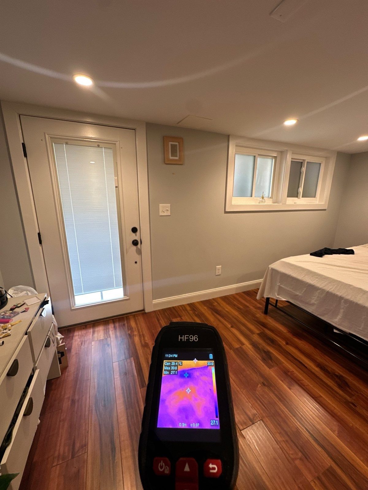 Thermal camera held over a dark-stained wood floor in a bedroom in Washington, DC, July 2025
