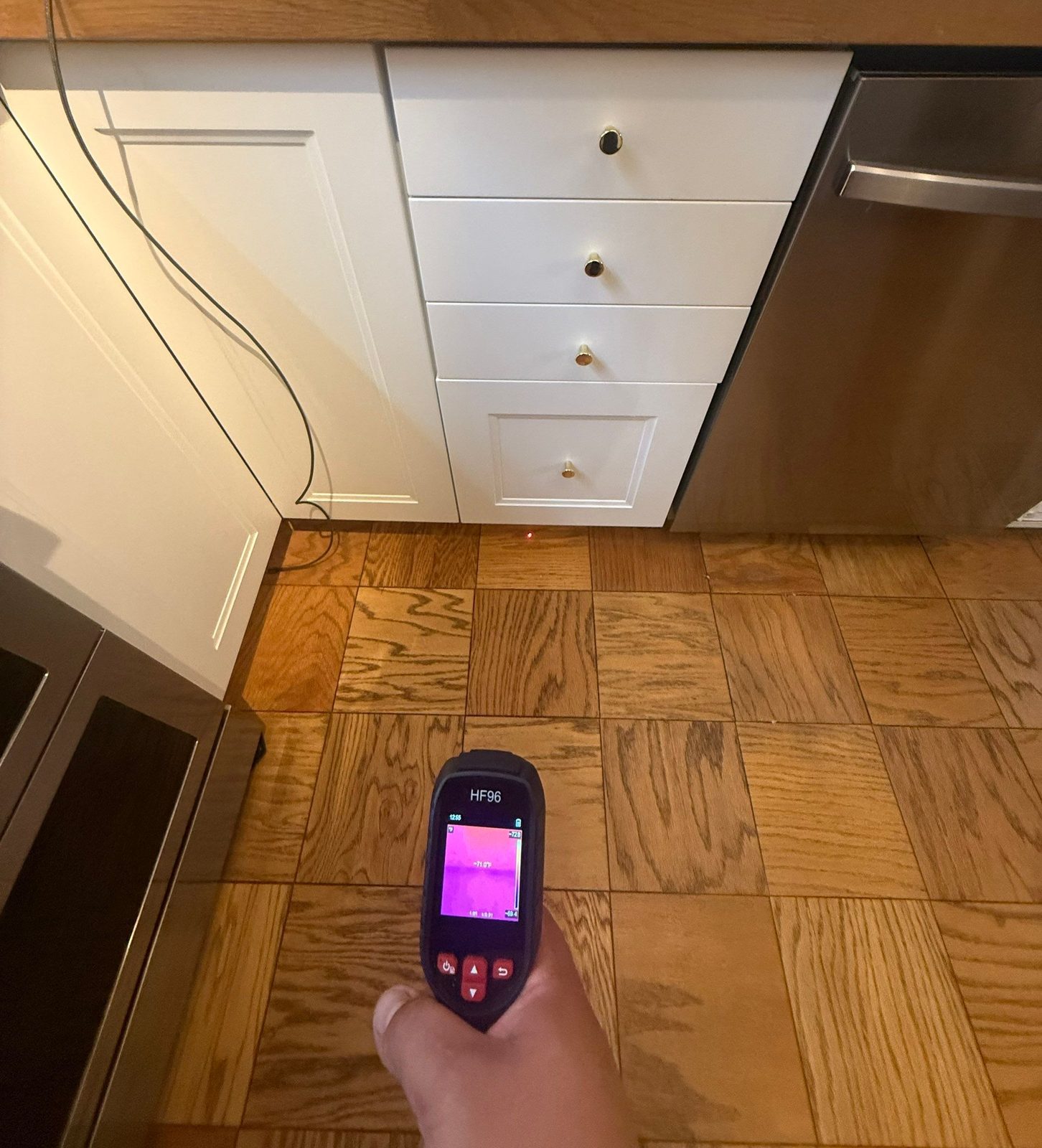 Thermal camera held over an oak parquet kitchen floor in a home in Southwest Waterfront, Washington, DC, September 2026