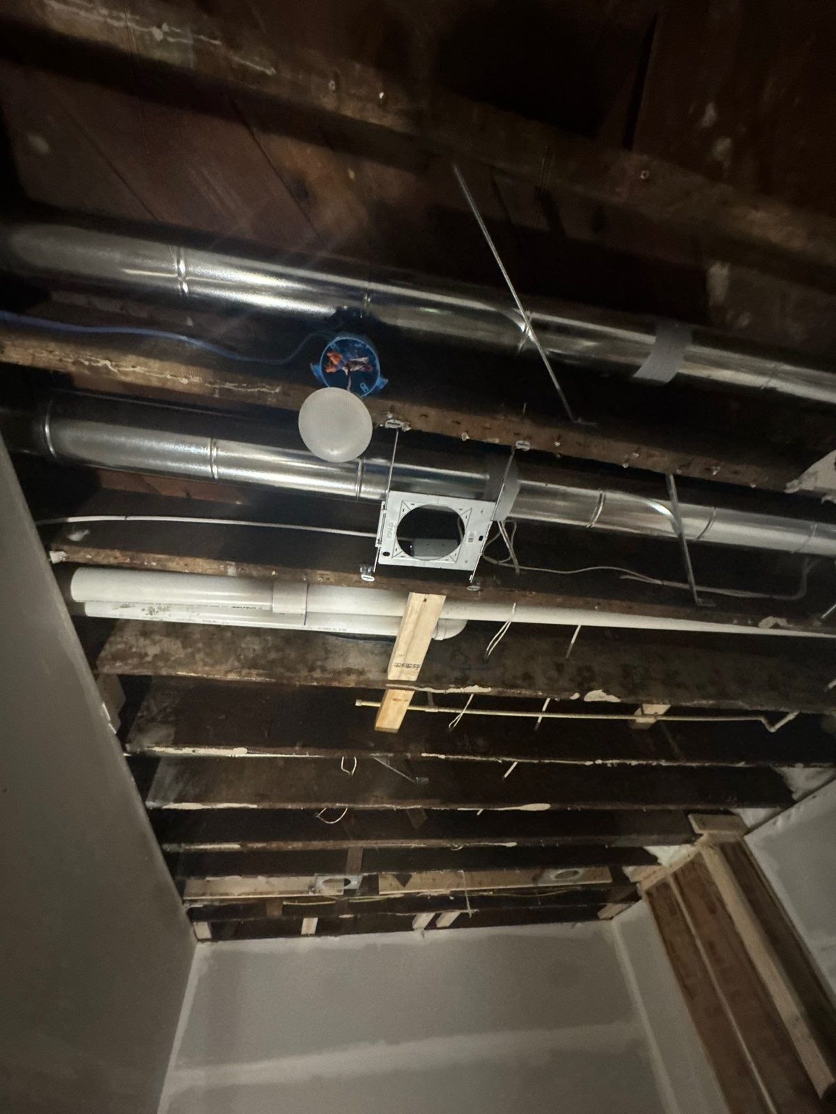 Ceiling opened to the joists with ductwork and wiring exposed in a rowhouse in Washington, DC, September 2026