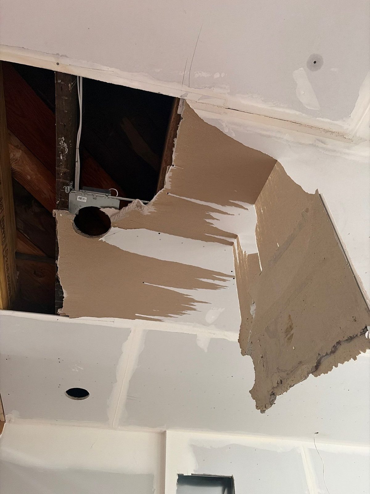 Torn drywall ceiling opened to the joists in a rowhouse in Washington, DC, August 2026