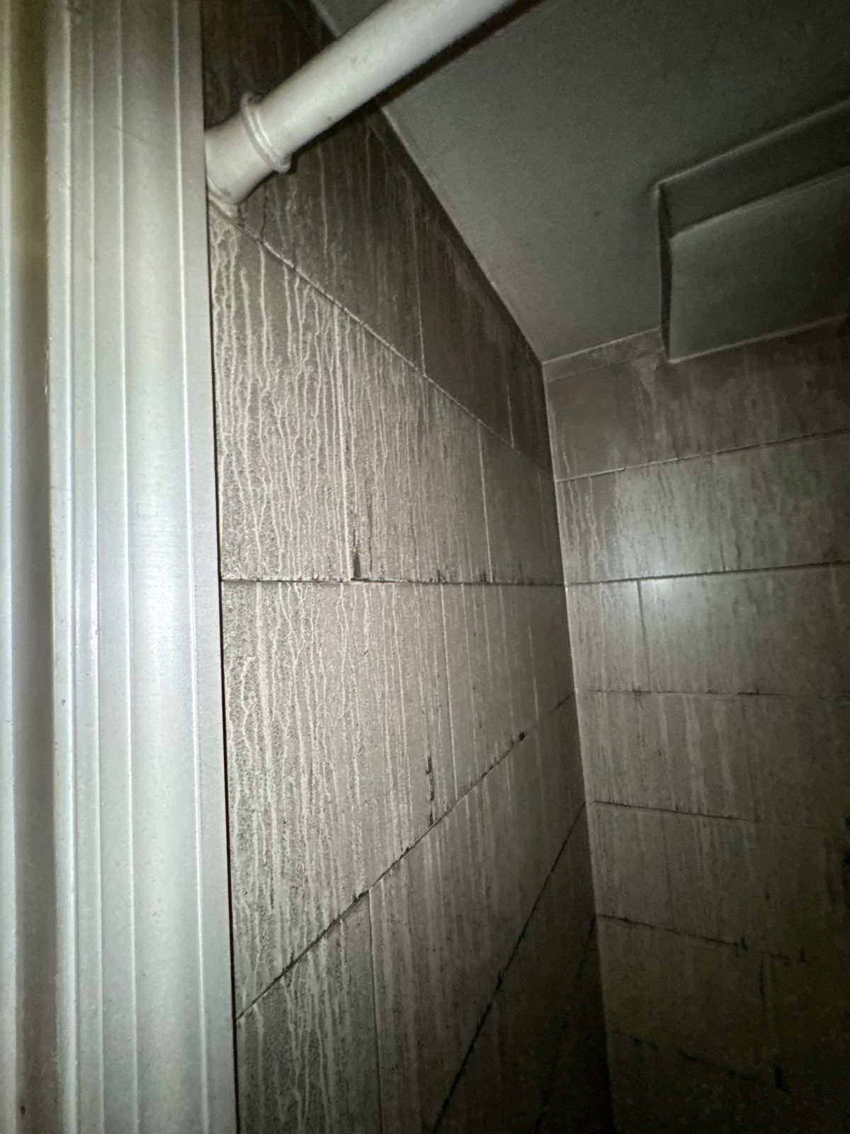 Soot streaks running down bathroom wall tile in a fire-damaged apartment in Washington, DC, August 2025
