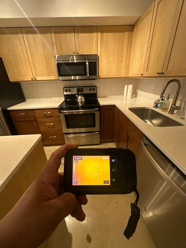 Thermal camera held over the kitchen floor of a garden-level apartment in Shaw, Washington, DC, July 2025